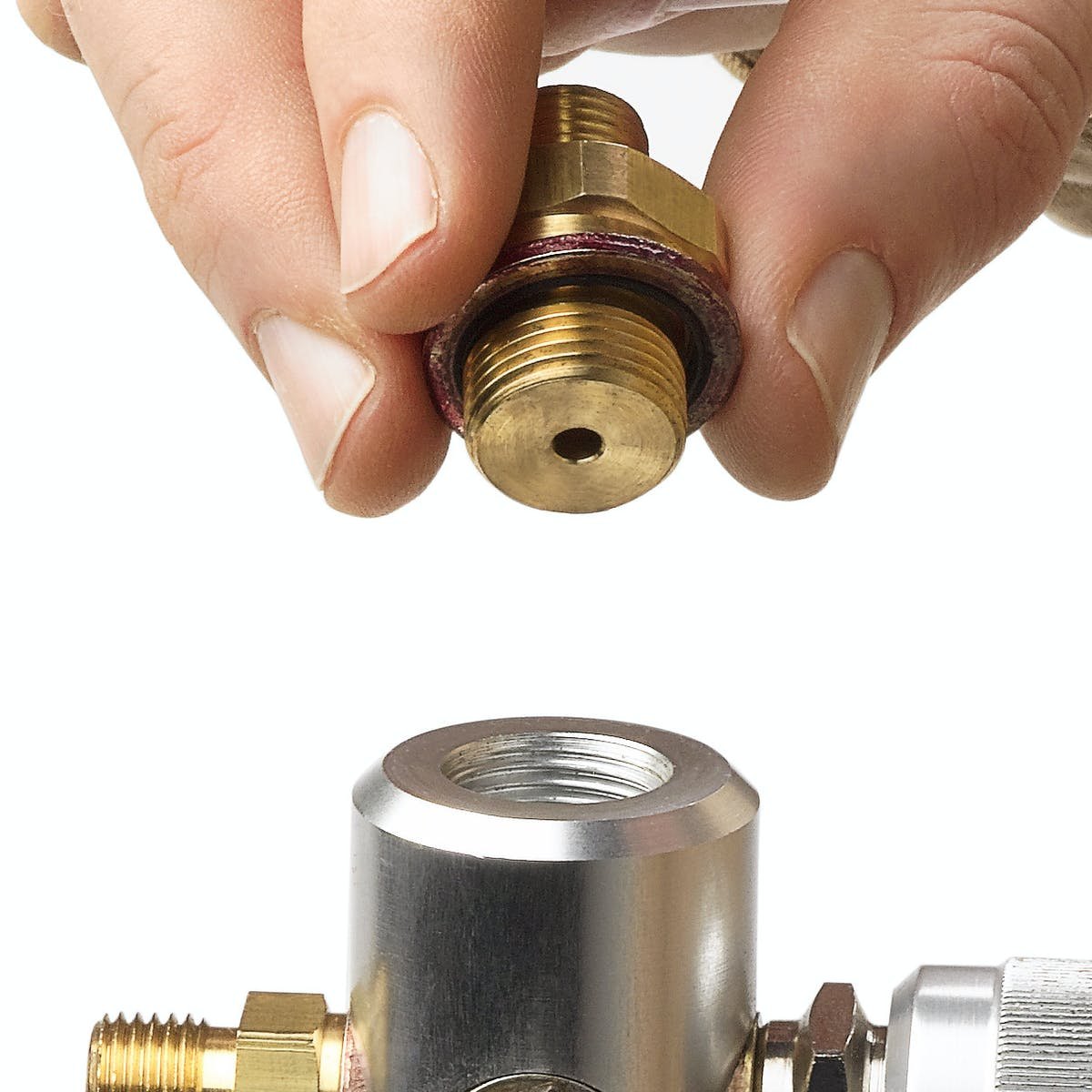 RALSTON INSTRUMENTS QTHA-2MB0-RS - 황동 퀵 테스트 어댑터를 손으로 잡고 연결하는 모습