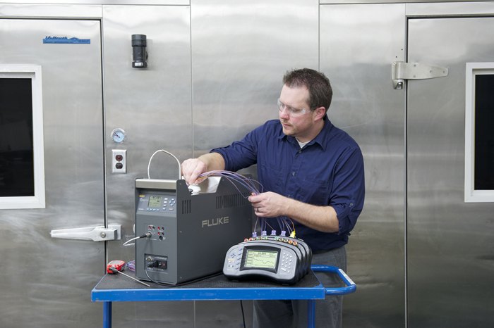 FLUKE CALIBRATION 9190A - 작업자가 드라이웰에 프로브를 넣어 교정하는 모습