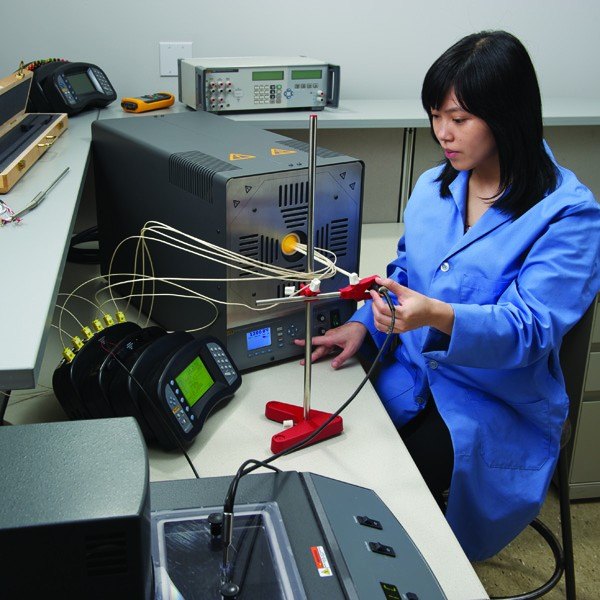 FLUKE CALIBRATION 9118A - 작업자가 열전대를 교정로에 넣어 교정하는 모습